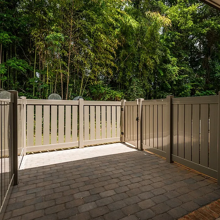 Charming patio with elegant fencing surrounded by lush greenery, offering a serene outdoor space for relaxation.