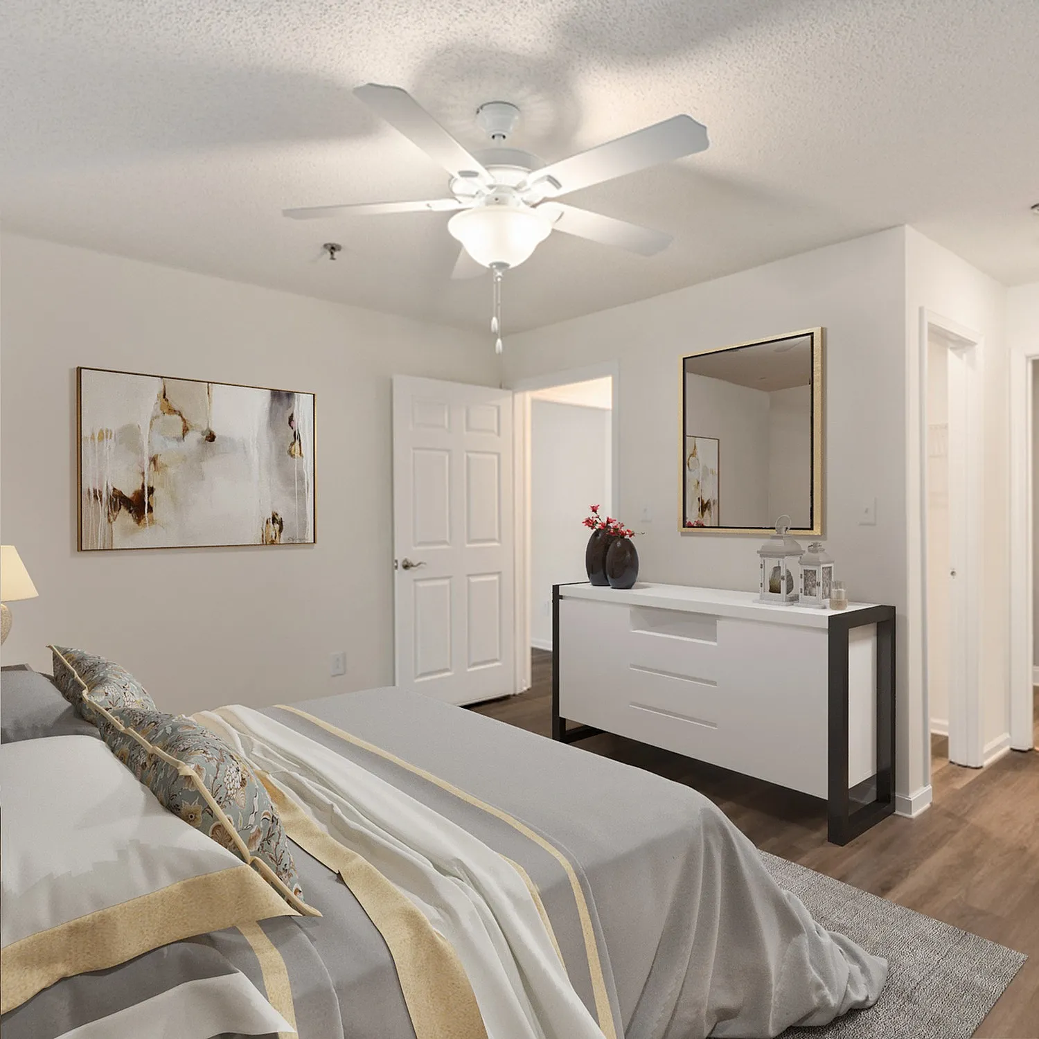 Elegant bedroom with modern decor, featuring a cozy bed with stylish linens, a sleek white dresser, and tasteful artwork, all under a bright ceiling fan.
