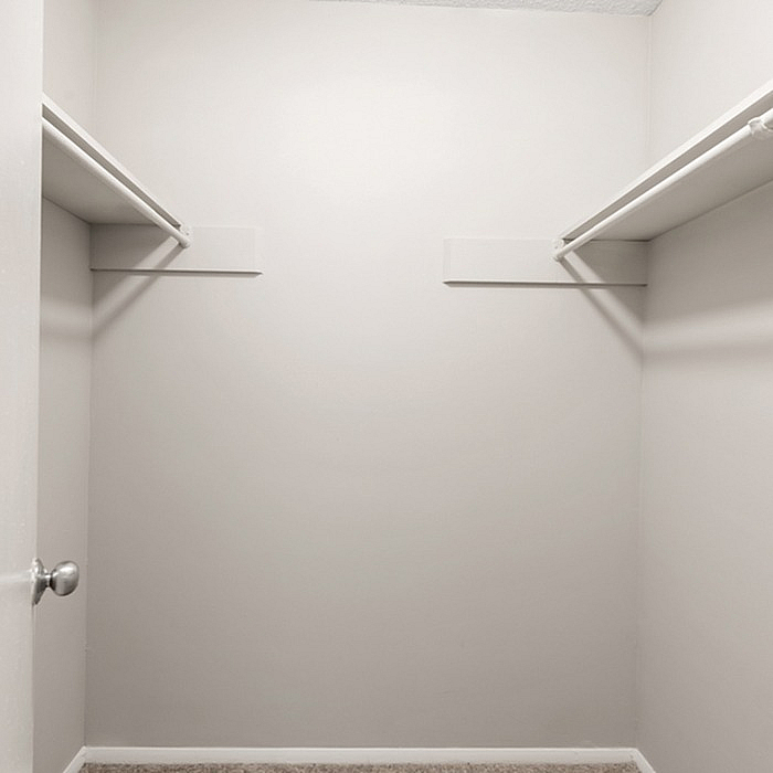 Spacious walk-in closet with neutral tones and ample shelving, ideal for stylish storage solutions.