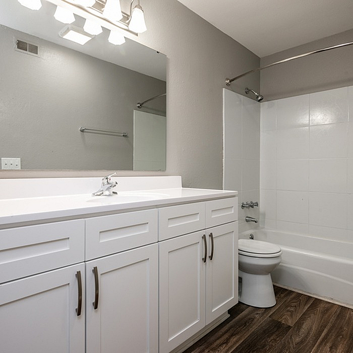 Modern bathroom with sleek white cabinetry, elegant lighting, and a stylish bathtub for a luxurious feel.