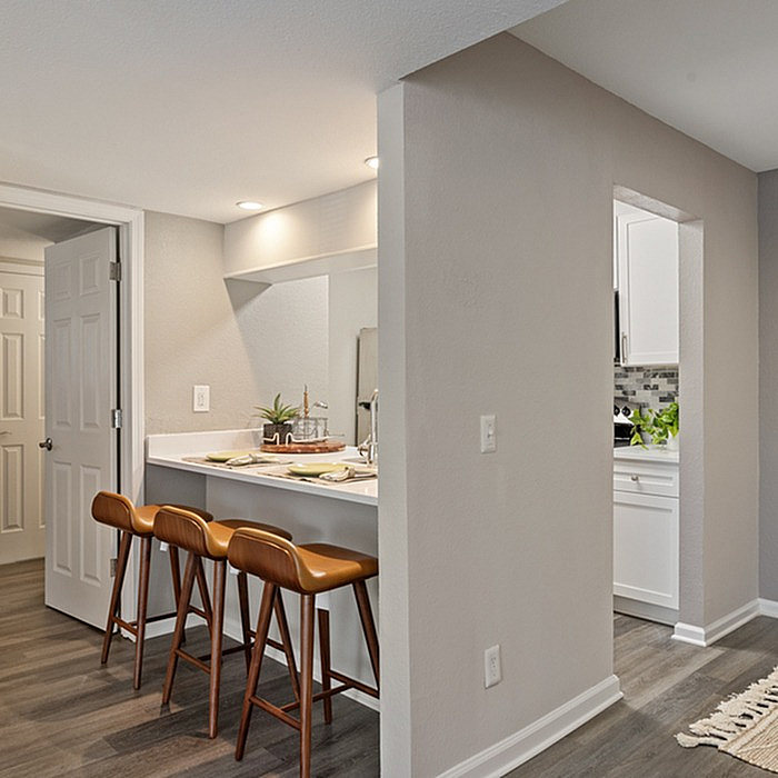 Chic apartment interior with a modern kitchen island, stylish bar stools, and elegant lighting.