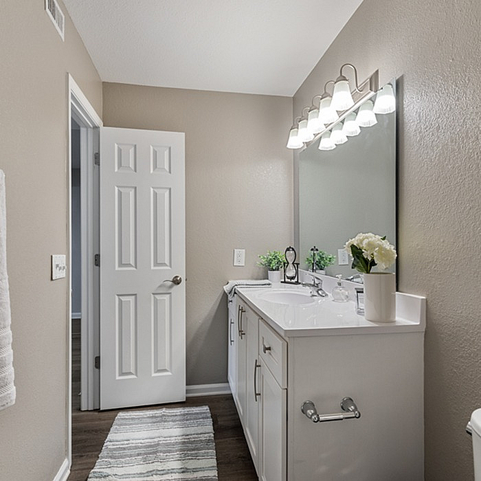Elegant bathroom design with a sleek vanity, large mirror, and modern lighting, offering a serene and refreshing atmosphere.
