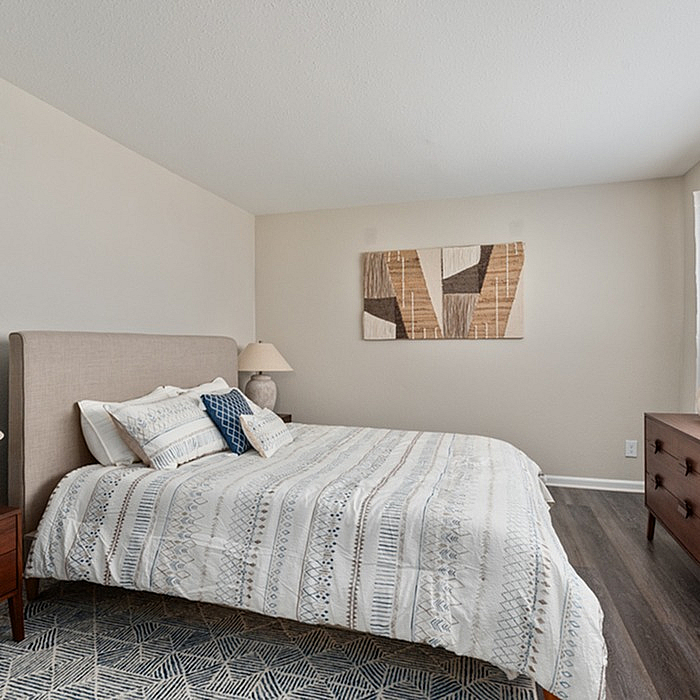 Elegant bedroom with cozy queen-sized bed, modern art, and warm lighting creating a serene and inviting atmosphere.