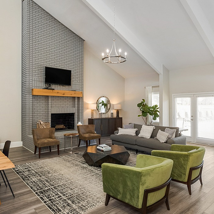 Elegant living room featuring a vaulted ceiling, stylish chandelier, and a cozy fireplace, complemented by plush seating and contemporary decor.