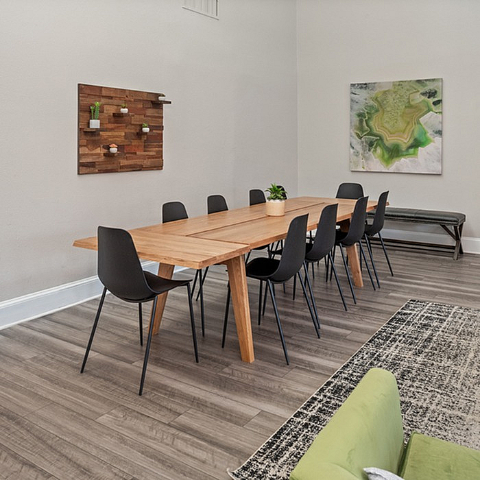 Elegant dining room with modern wood table, stylish black chairs, and tasteful wall art creating a cozy, inviting atmosphere.