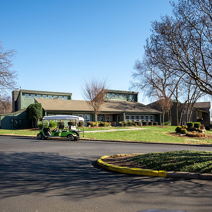 Charming residential community with lush greenery, modern architecture, and a convenient golf cart, perfect for comfortable living.