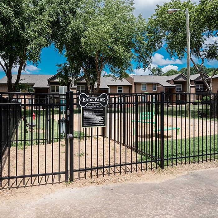 Charming pet-friendly Bark Park with bright play equipment and lush green surroundings, nestled in a cozy residential area.