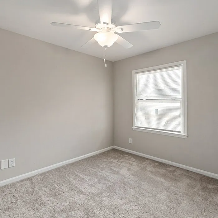 Bright, airy room with soft carpet and large window, perfect for enhancing your home with abundant natural light.
