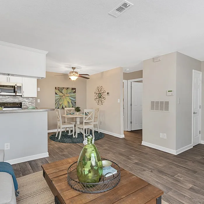 Bright and inviting open-concept living area with a modern kitchen, cozy dining space, and elegant hardwood floors.