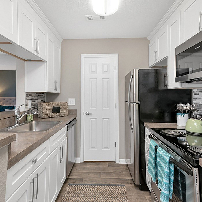 Elegant modern kitchen with stainless steel appliances, chic white cabinetry, and stylish backsplash, perfect for culinary creativity.
