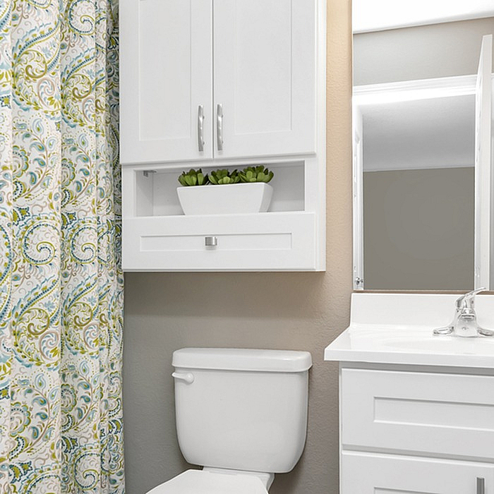 Chic bathroom design with modern white cabinets, elegant countertop, and decorative shower curtain adding a vibrant touch.