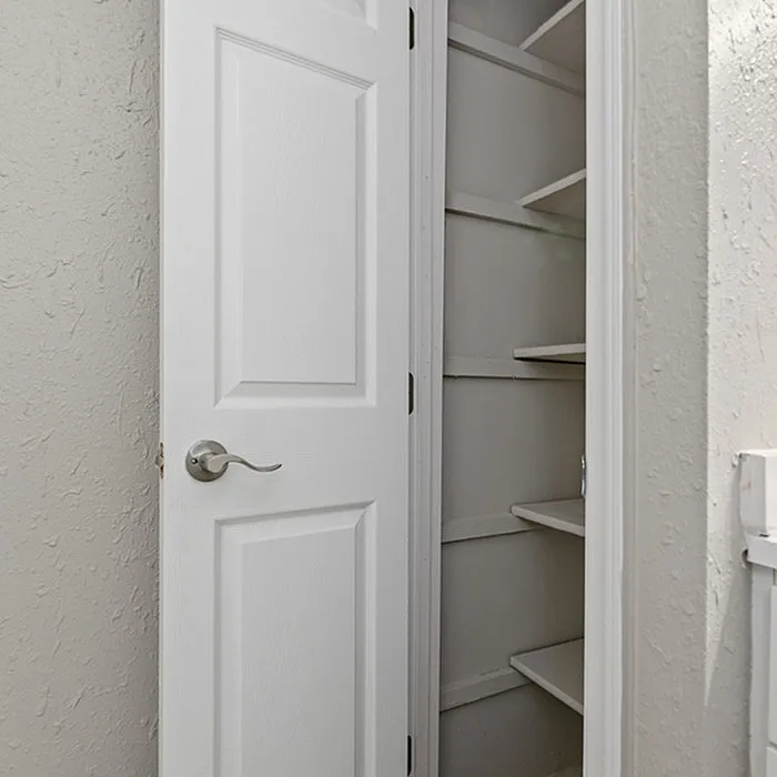 Elegant white closet with built-in shelves, perfect for organized storage solutions.