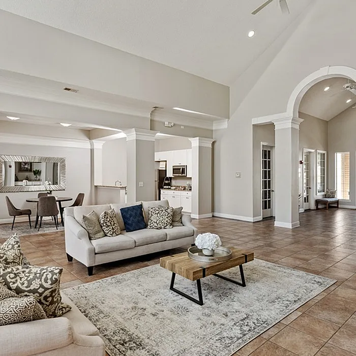 Spacious open-concept living room with elegant arches, cozy seating area, and inviting dining space.