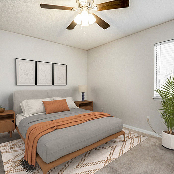 Cozy bedroom in modern apartment, featuring a plush bed with stylish orange accents, elegant nightstands, and a chic ceiling fan.