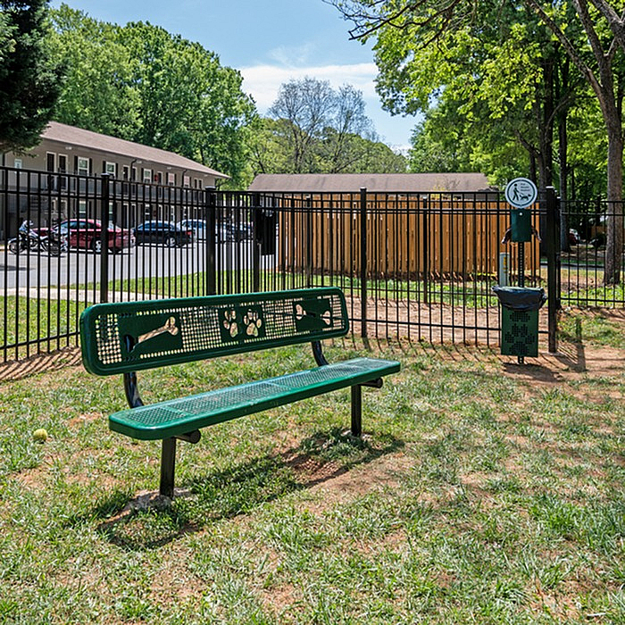 Inviting dog park with a charming green bench and scenic views, perfect for pet-friendly living.