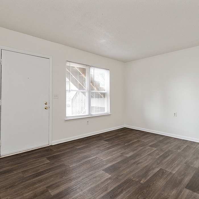Bright and inviting room with elegant hardwood flooring and large windows offering natural light.