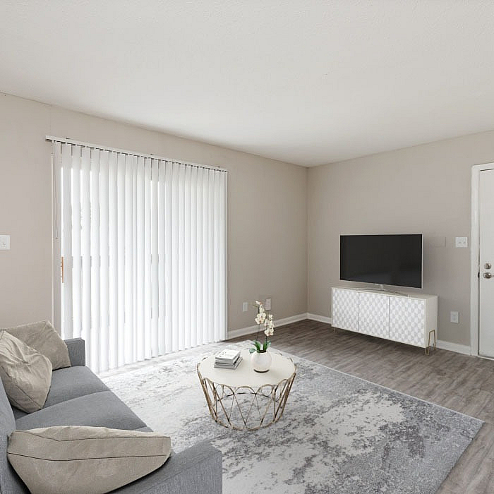 Bright and modern living room featuring a cozy gray sofa, stylish coffee table, and sleek TV setup, with abundant natural light from large sliding doors.
