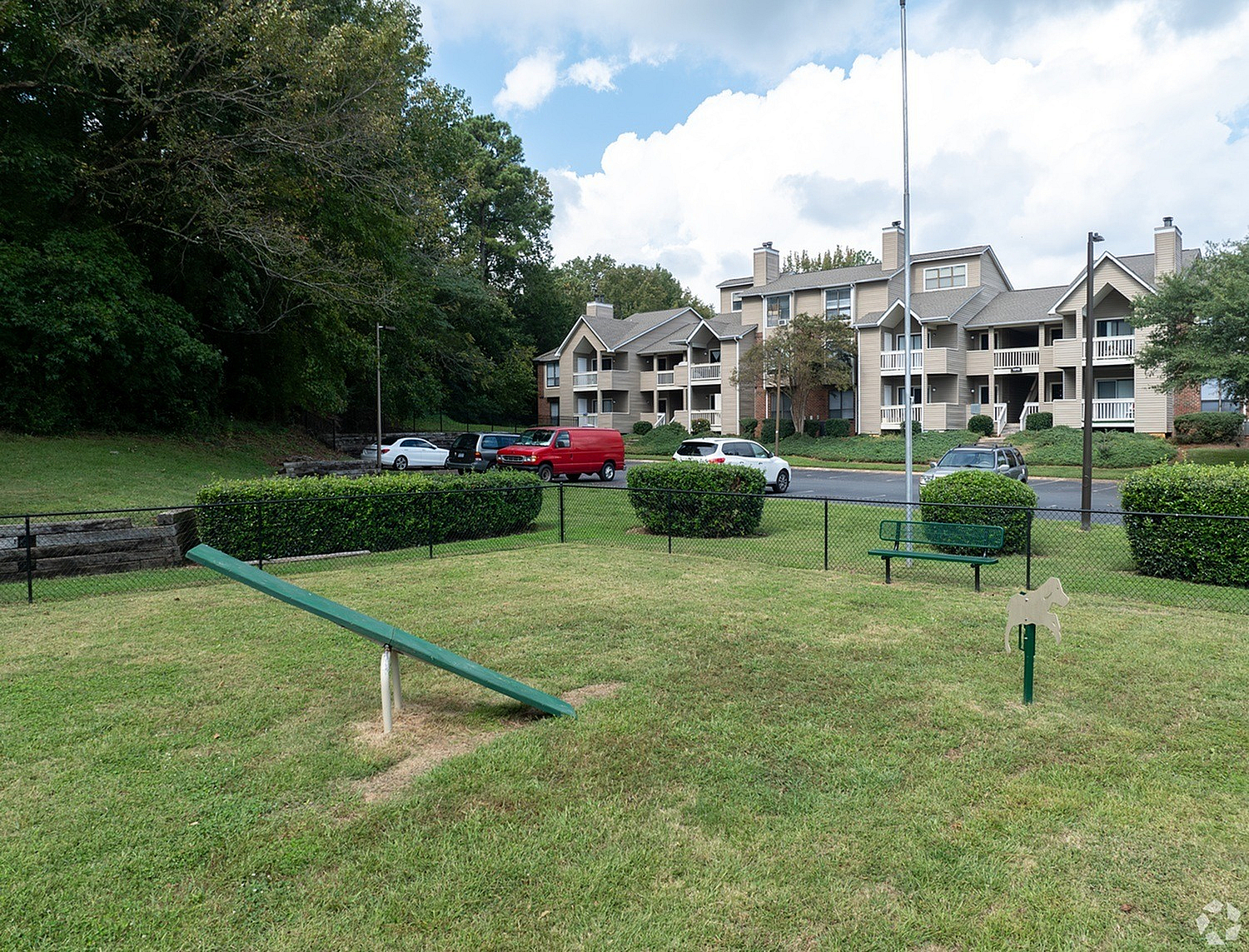 Inviting suburban apartment complex with charming facades, lush green surroundings, and a well-maintained playground area.