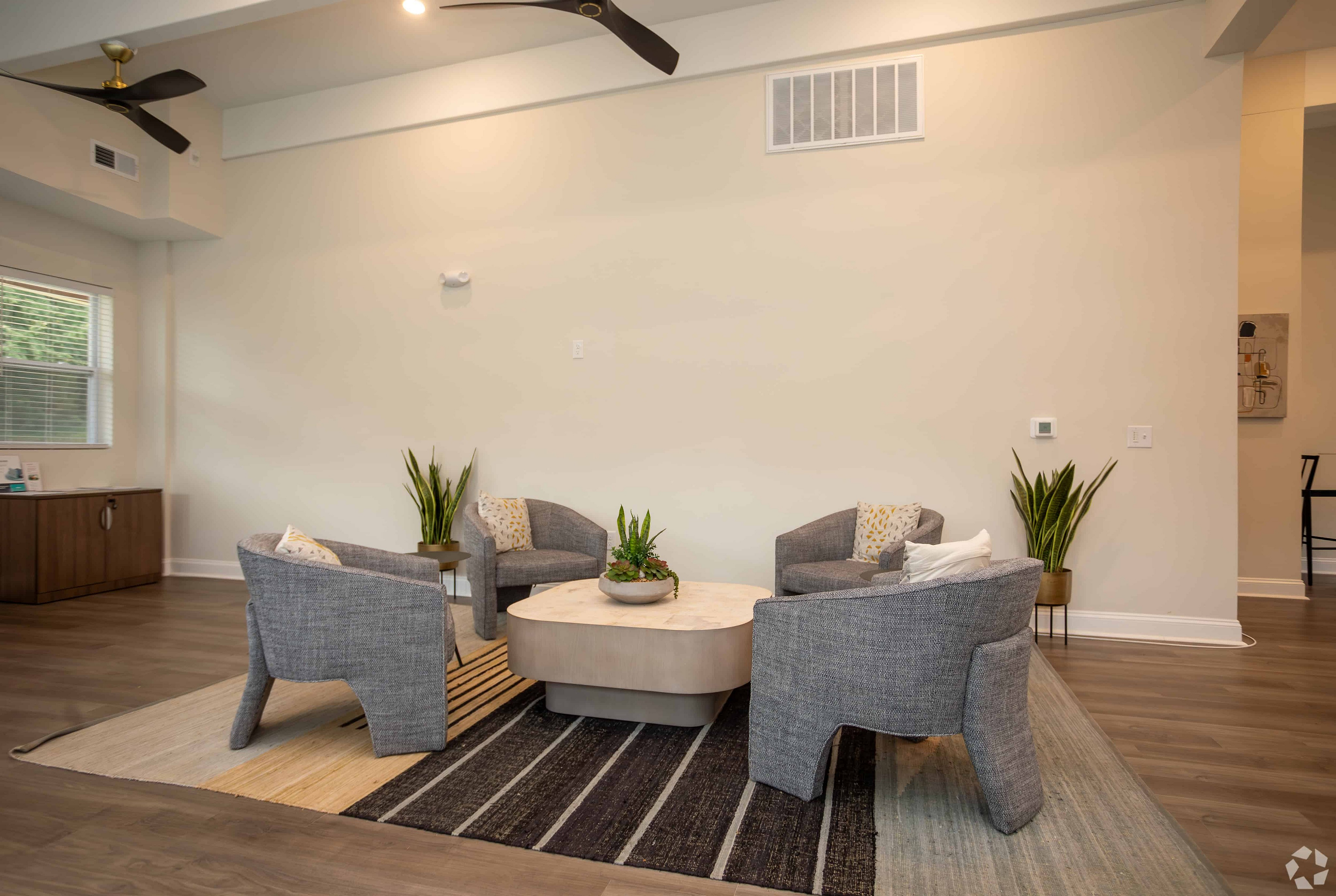 Inviting living room with modern gray armchairs, elegant coffee table, and soft lighting, perfect for relaxation.