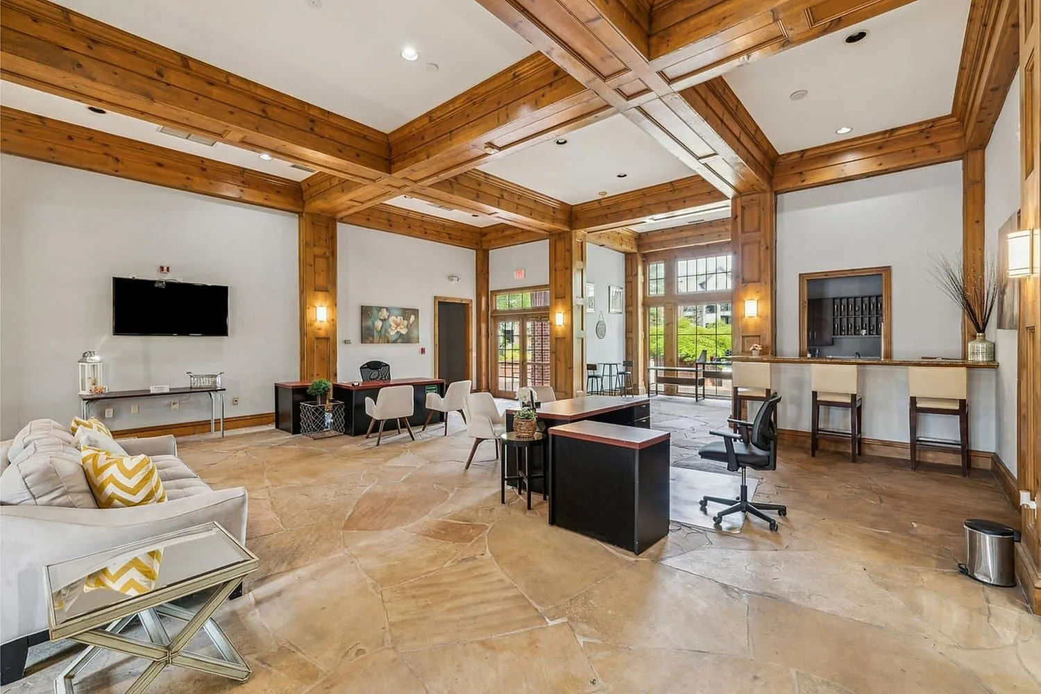 Elegant apartment lobby with stunning wood beam ceilings, modern seating area, large windows, and a welcoming reception desk.