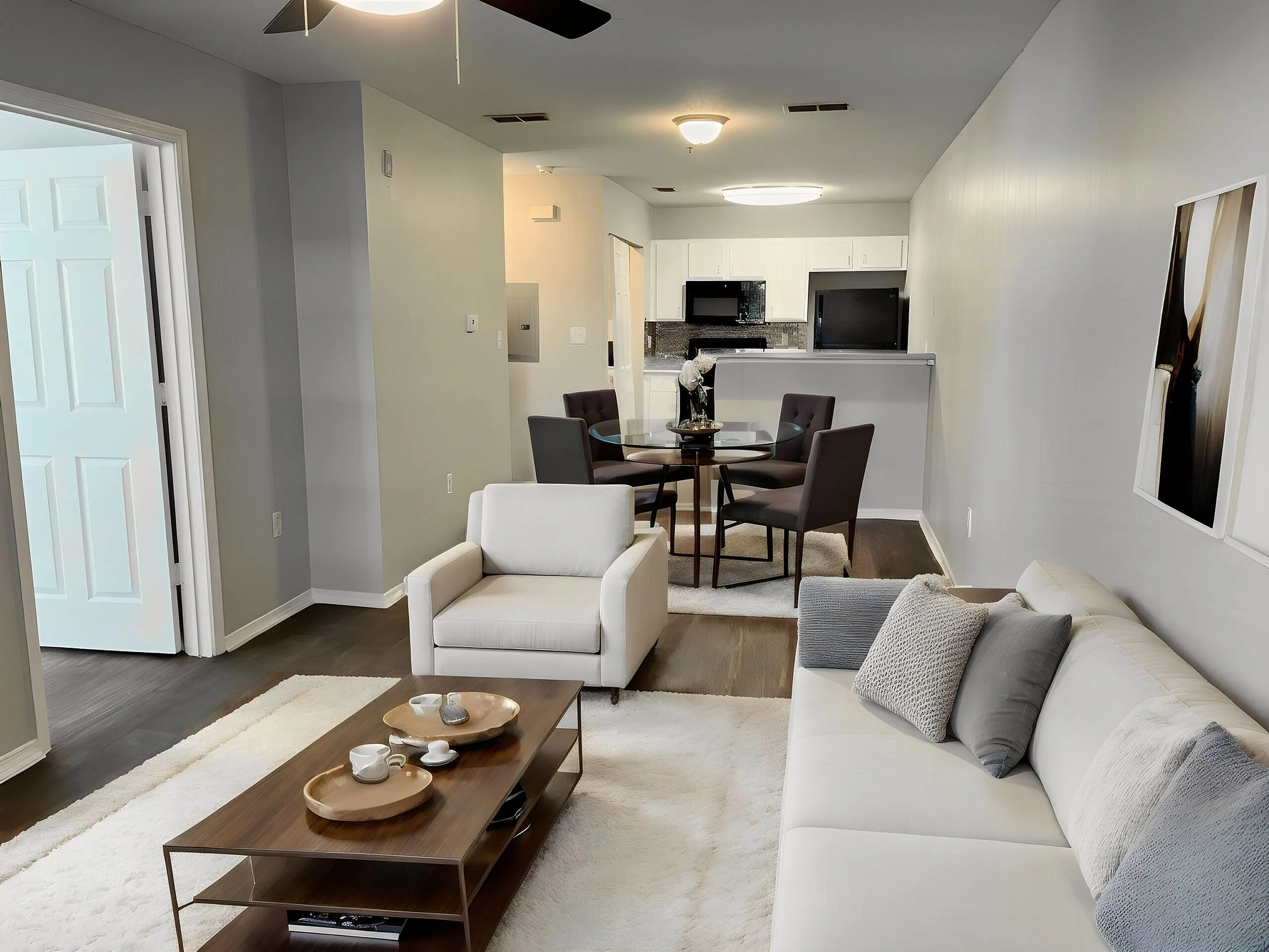 Elegant living room with modern furniture, plush seating, open-plan dining area, and a stylish kitchen in the background. Inviting atmosphere with soft lighting and tasteful decor.