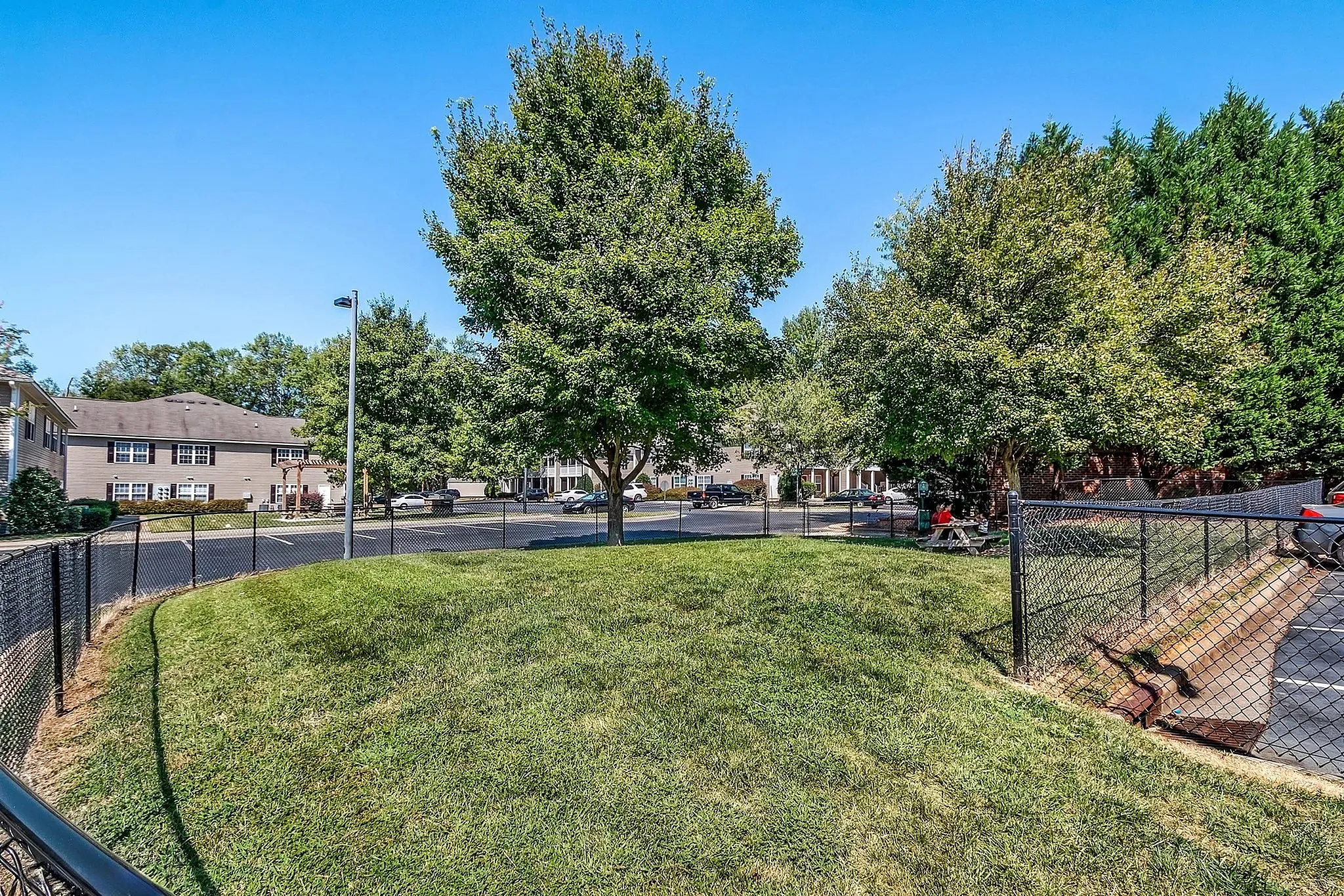Charming community view featuring lush green lawns, mature trees, and a peaceful residential setting.