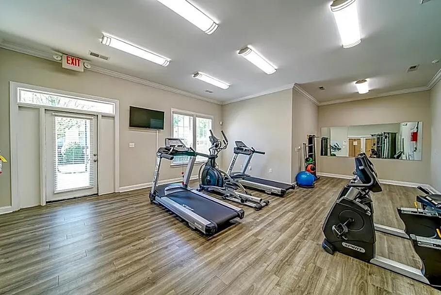 Modern fitness room with state-of-the-art cardio equipment and bright natural lighting.