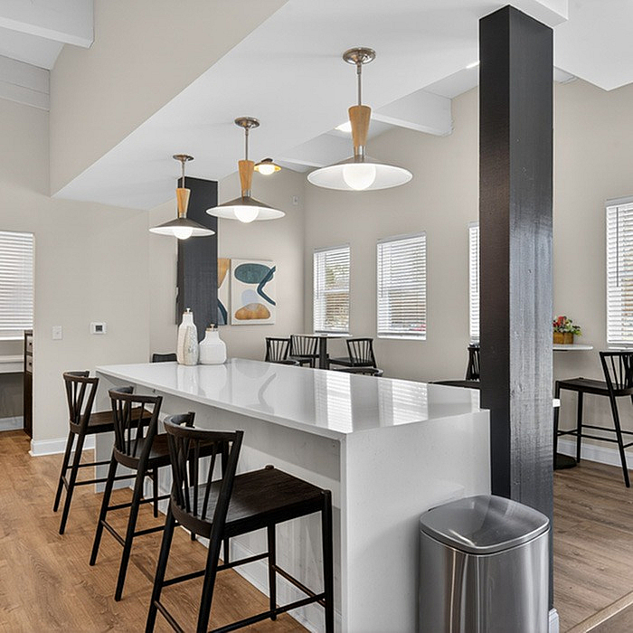 Chic open kitchen with a sleek white island, modern pendant lighting, and stylish bar seating, perfect for entertaining.