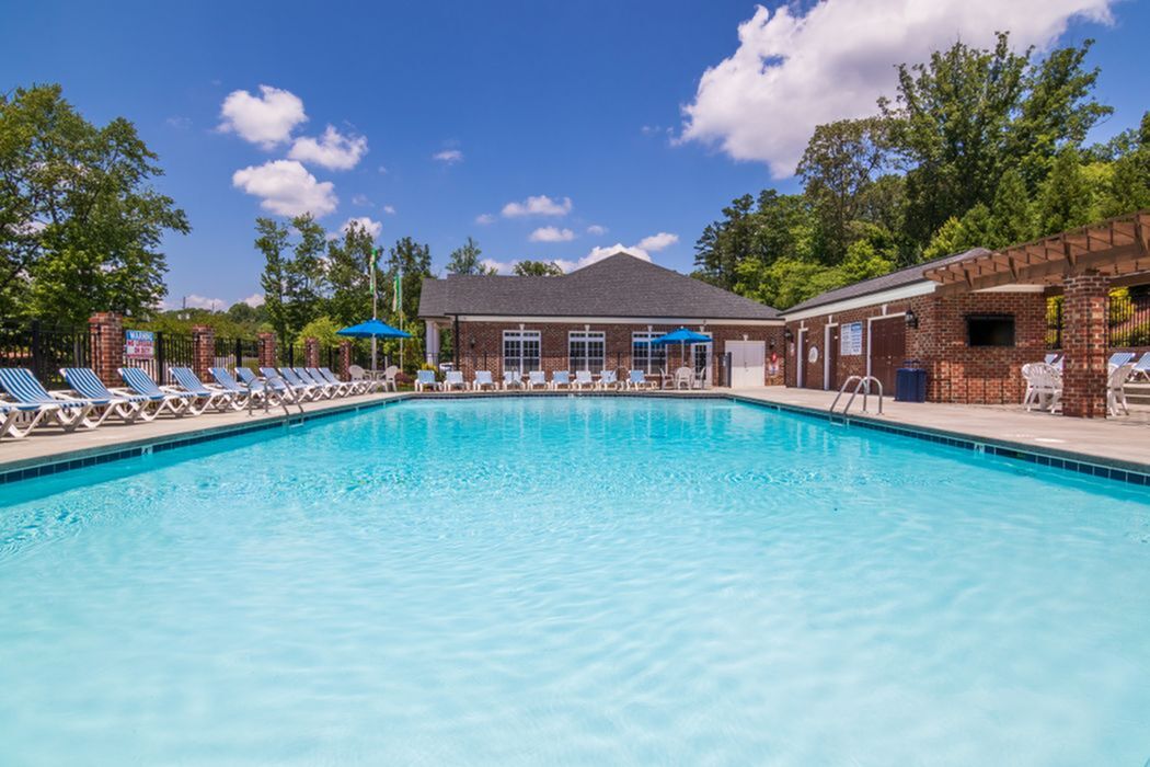 Gorgeous outdoor swimming pool area with clear blue water, surrounded by sun loungers and lush greenery, perfect for relaxation and leisure.