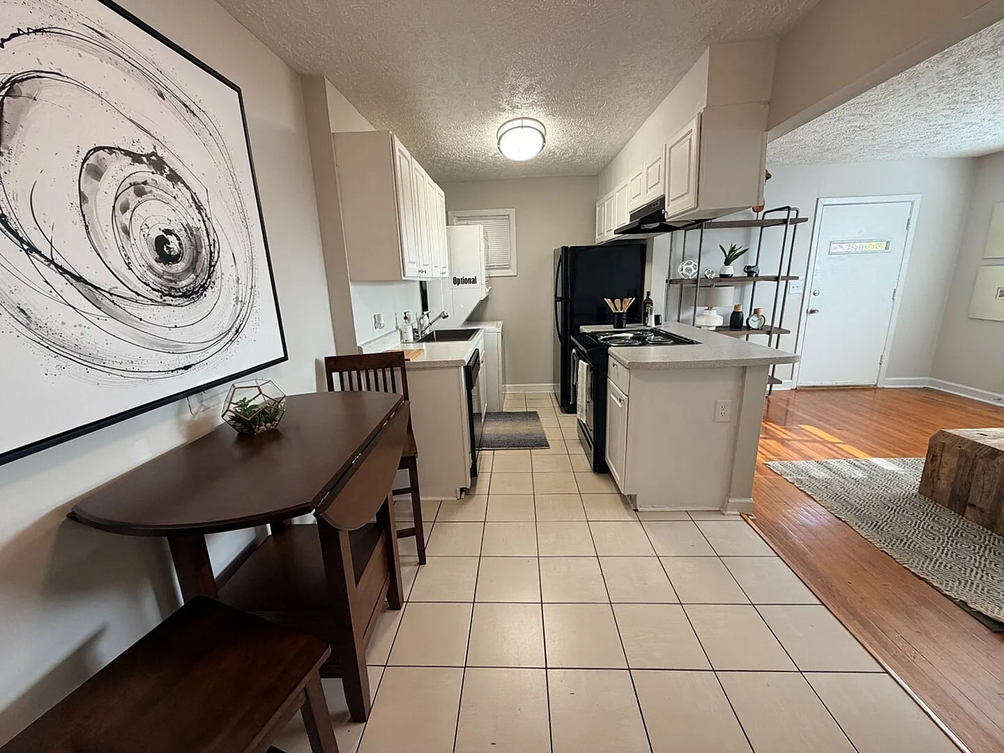 Charming open kitchen and dining area featuring modern appliances, stylish art, and seamless transition to cozy living space.