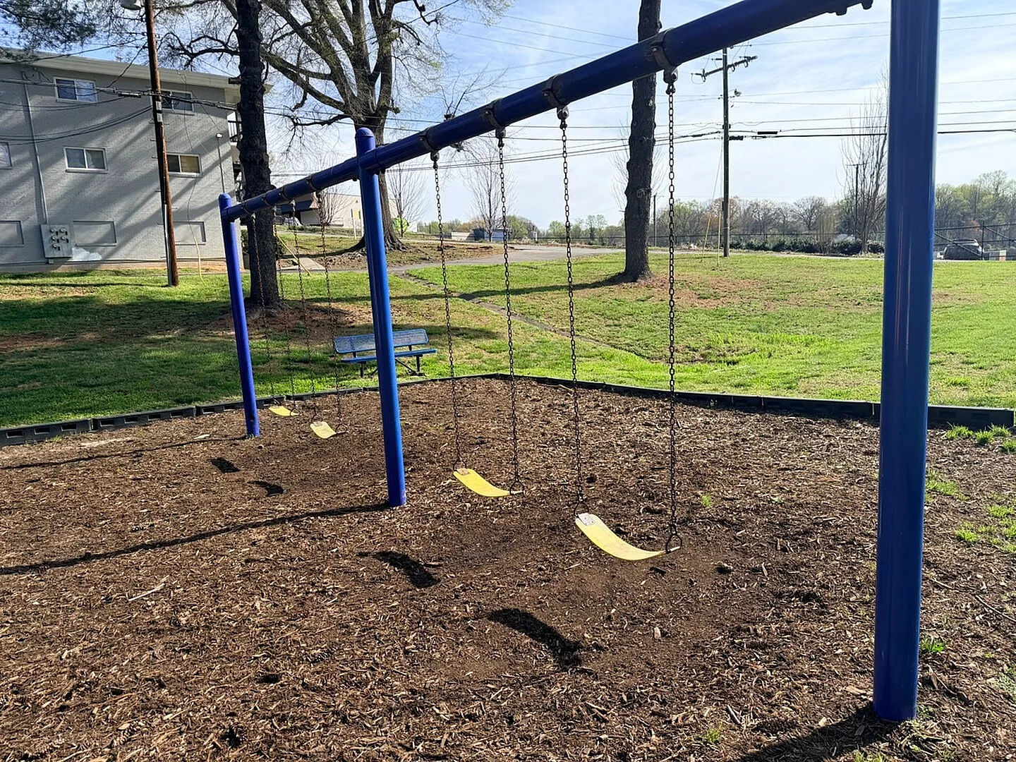 Inviting playground swing set surrounded by lush green space, perfect for family fun and outdoor activities.
