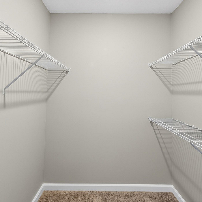 Spacious walk-in closet with ample shelving for organized storage in modern apartment.