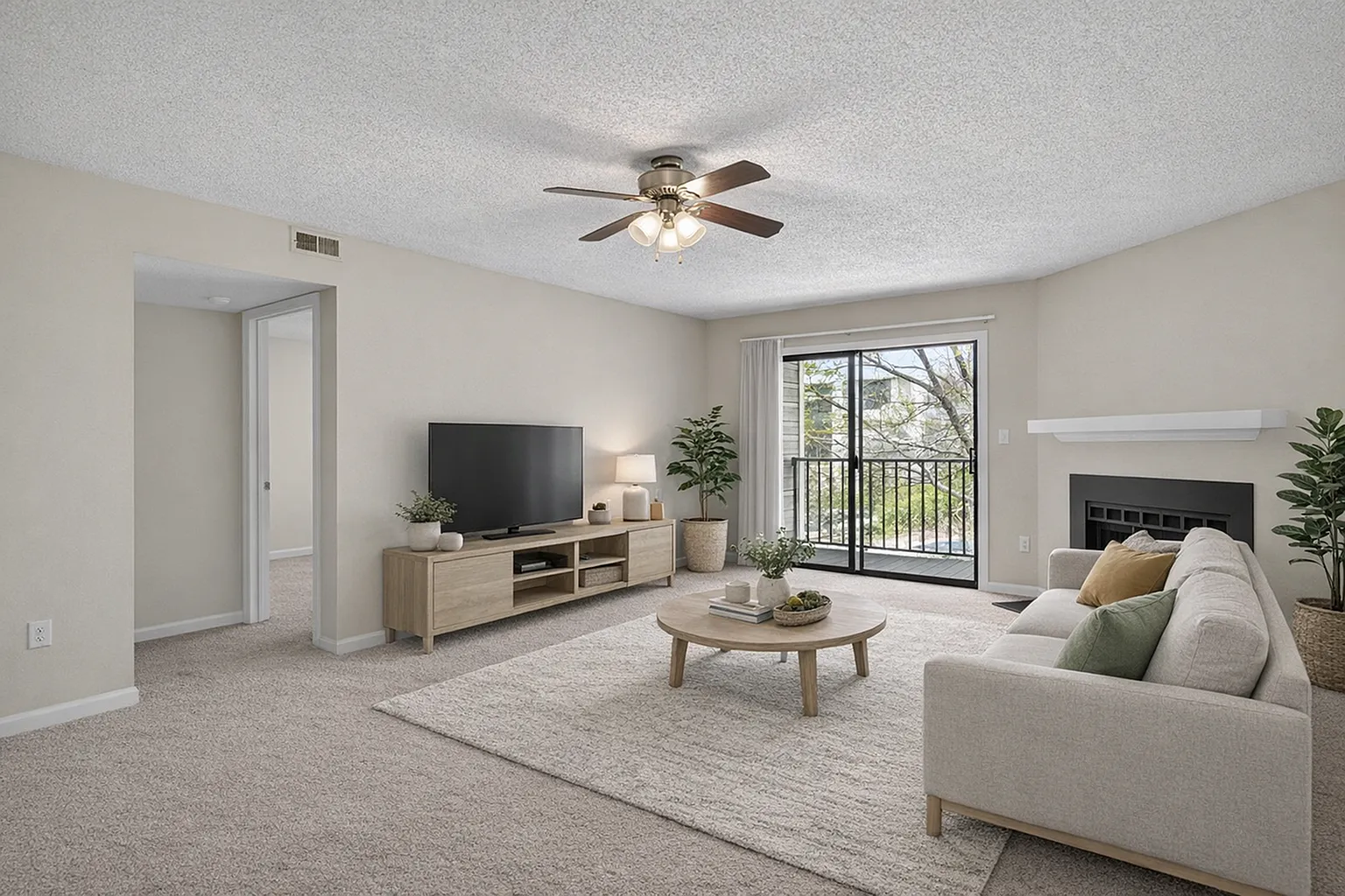 Bright living room with modern decor, featuring a cozy beige sofa, flat-screen TV, and elegant coffee table, overlooking a balcony with sliding glass doors.