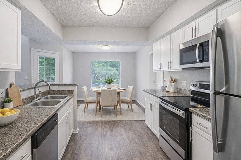 Modern kitchen with stainless steel appliances, sleek countertops, and a cozy dining area, ideal for entertaining.