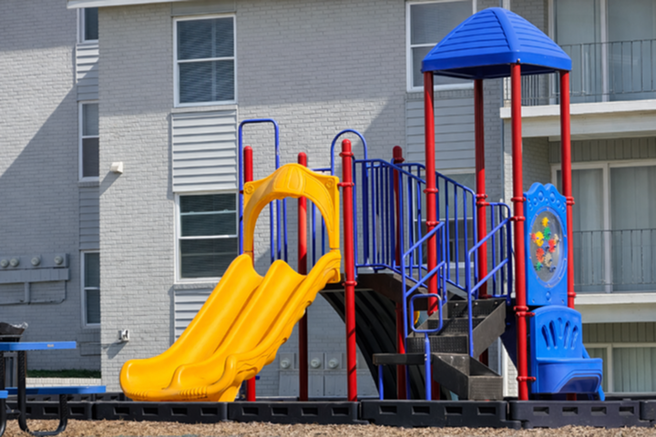 Vibrant apartment playground featuring colorful slides and climbing structures, perfect for family-friendly living.