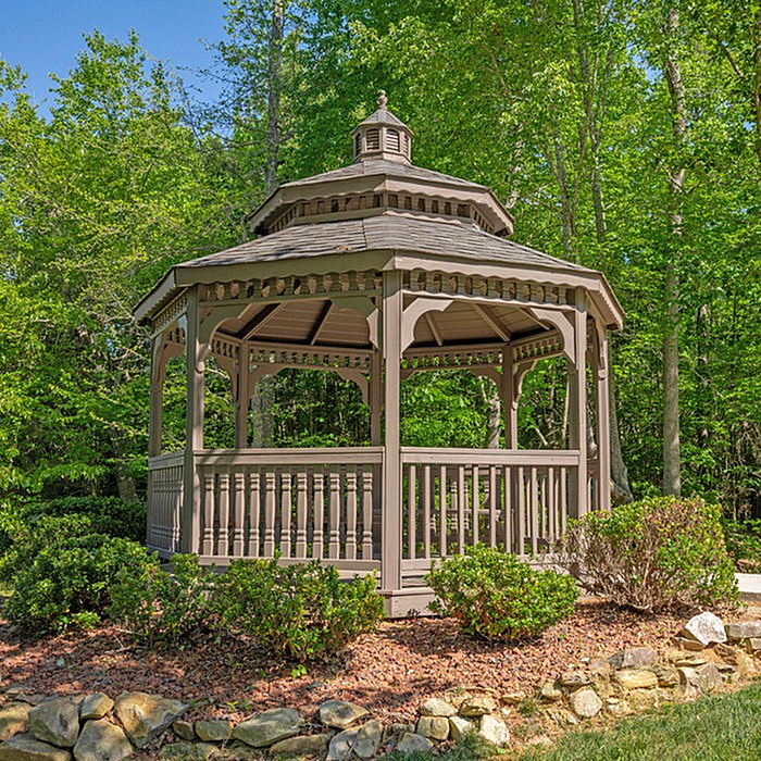 Charming wooden gazebo nestled in lush greenery, perfect for outdoor relaxation and gatherings.