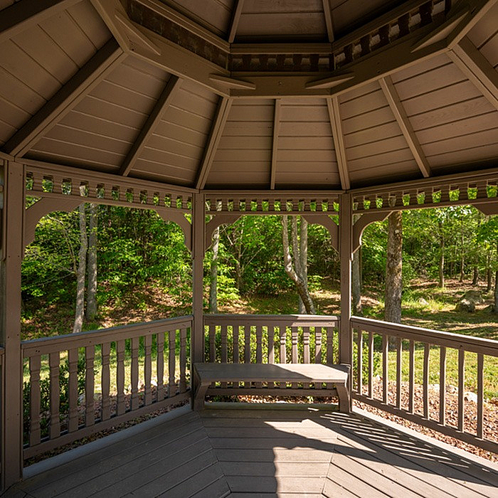 Charming wooden gazebo with stunning views of lush greenery, perfect for relaxation and outdoor enjoyment.