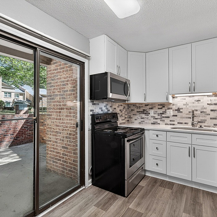 Modern kitchen with sleek cabinetry, stainless steel appliances, and cozy outdoor patio access.