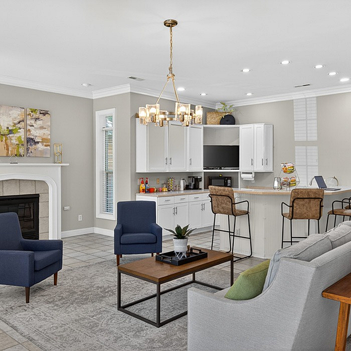 Elegant open-concept living area featuring modern kitchen, cozy seating, fireplace, and stylish lighting.