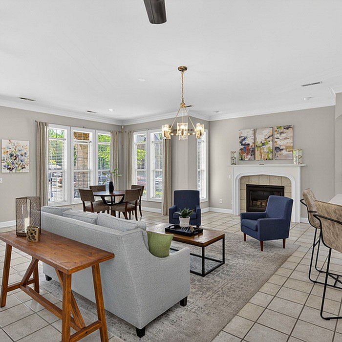 Elegant living room with abundant natural light, modern furniture, and a charming fireplace, perfect for entertaining.