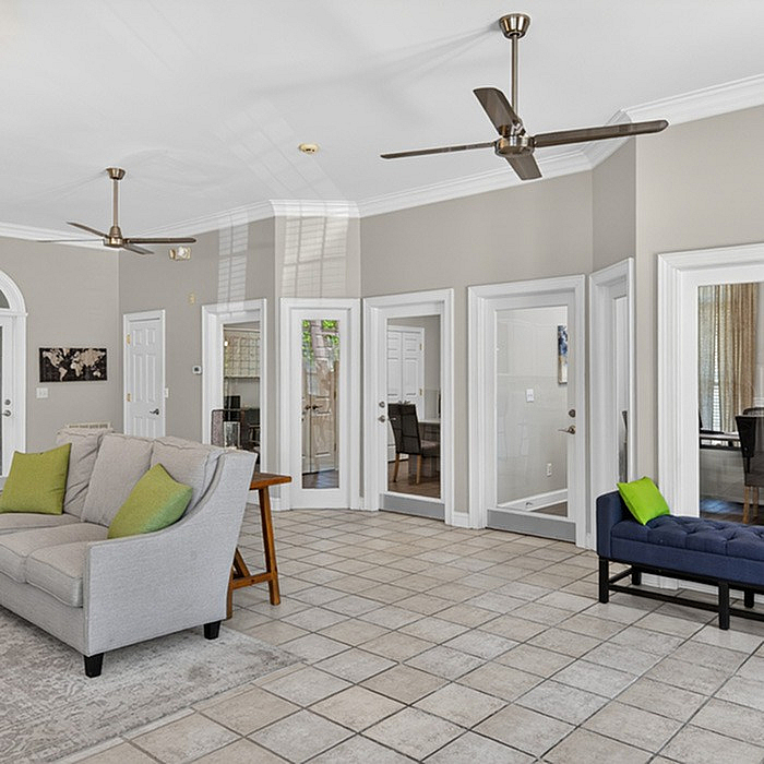 Bright and airy living space with modern ceiling fans, neutral tones, and elegant tile flooring, perfect for comfortable living.