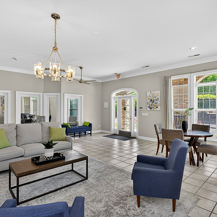 Elegant open-concept living area featuring modern furnishings, stylish chandelier, and large windows offering abundant natural light.
