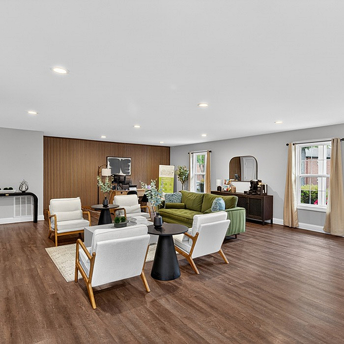 Spacious and modern living area featuring elegant furniture, warm wood flooring, and abundant natural light.