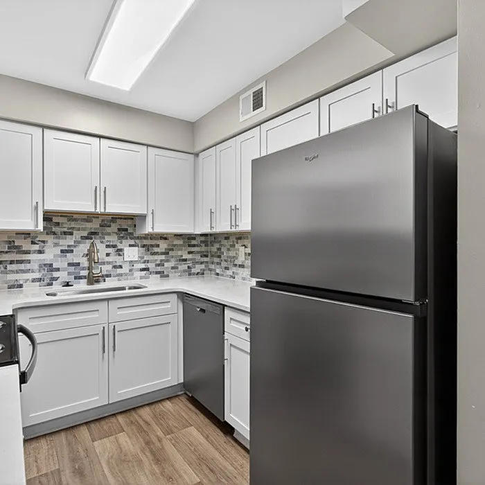 Modern kitchen with sleek stainless steel appliances, elegant white cabinetry, and stylish mosaic backsplash.