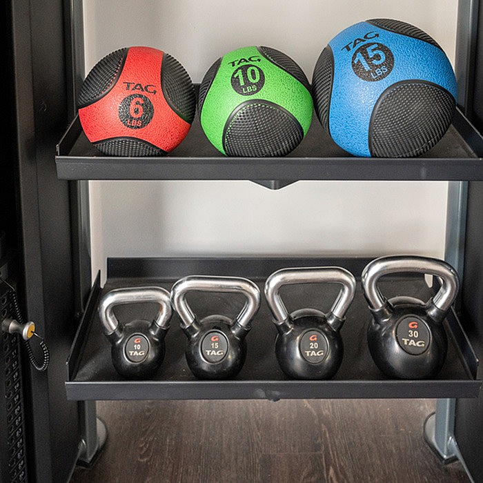 Modern fitness rack displaying vibrant medicine balls and sleek kettlebells, perfect for a stylish home gym setup.