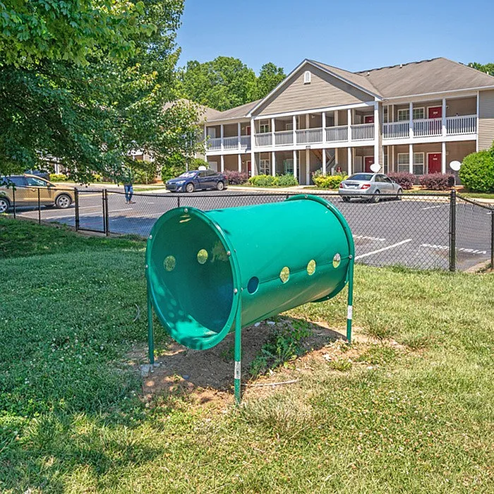 Inviting apartment complex with charming two-story design, ample parking, and a vibrant outdoor play area.