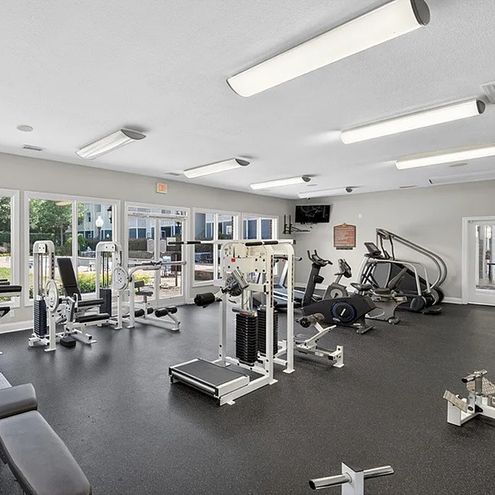 Bright and spacious fitness center featuring modern exercise equipment with large windows offering scenic views.