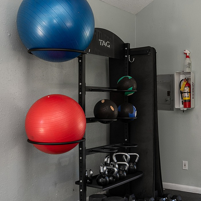 Inviting home gym corner with vibrant exercise balls, kettlebells, and medicine balls neatly organized, offering a dynamic workout space.