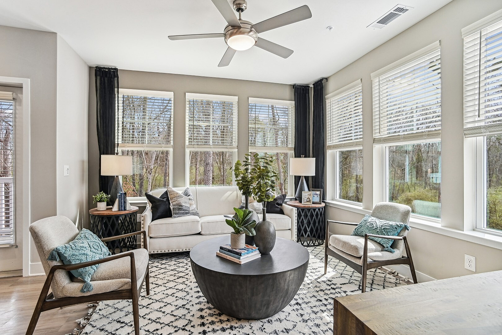 Bright and airy living room with large windows, stylish decor, and cozy seating; perfect for relaxation and entertaining.