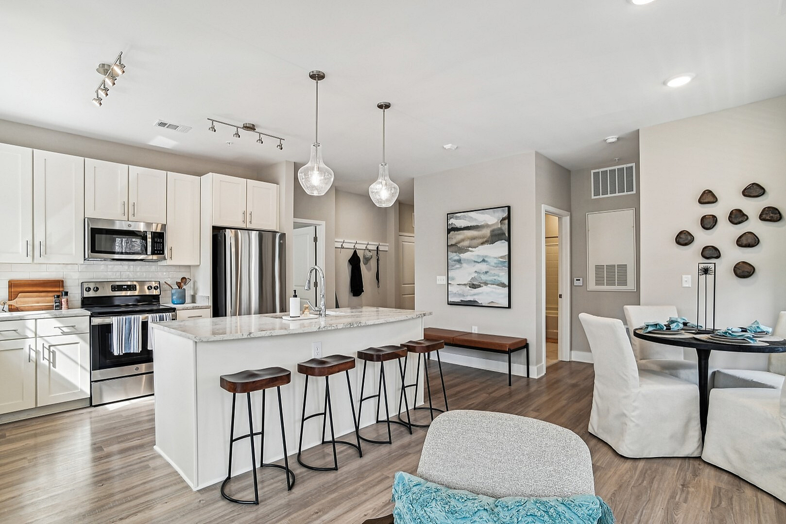 Chic modern kitchen with marble countertops, stainless steel appliances, and cozy dining area with elegant décor.
